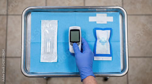 Doctor Hand in Blue Glove Holding Digital Spirometer on Sterile Tray