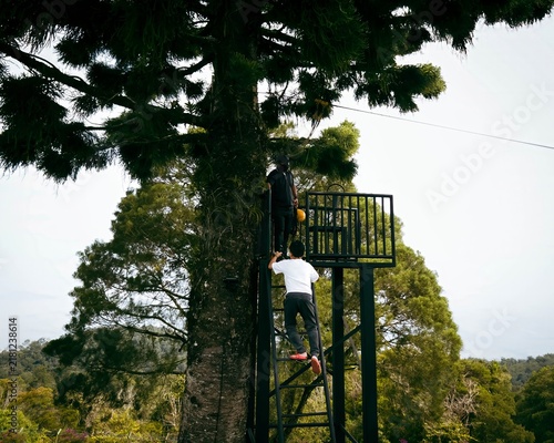 Young boy climbing the stairs and trying the flying fox zip line in Malaysia