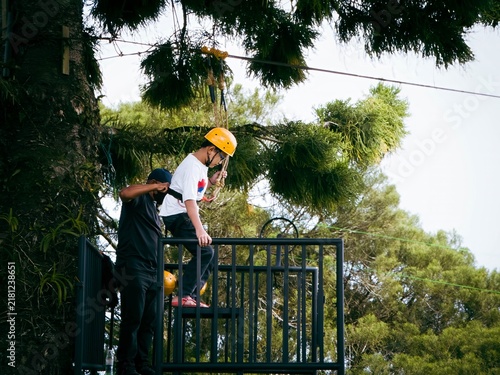 Gunung Jerai, Malaysia - August 7, 2022 Young boy trying the flying fox zip line in Malaysia