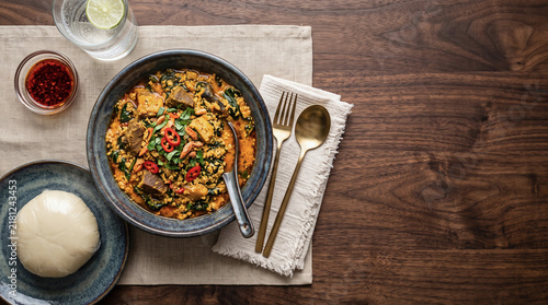 African egusi soup dish, on a table seen from above with copy space, ad image traditional African food