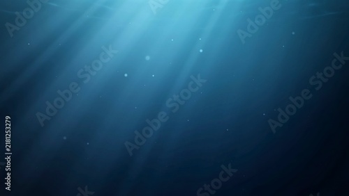 Sunbeams piercing through deep blue underwater water surface