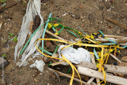 Discarded plastic straps, packaging materials and wood fragments scattered on a construction area, showing waste management challenges during building operations