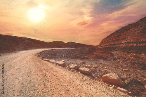 Mountain desert landscape. Dirt road in National Park Makhtesh Ramon Crater in Negev desert, Israel