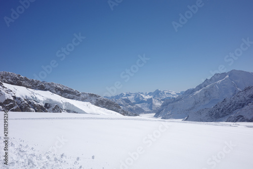 Fotografía A broad glacier basin rimmed by rocky snow-covered ridges opens toward distant p