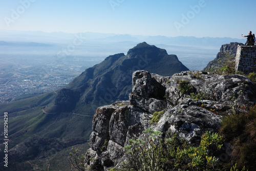 Obraz na płótnie A stone viewing platform on the rim of Table Mountain looks out over a rugged neighbouring peak and the hazy plain of Cape Town, South Africa