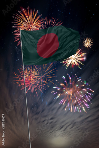 Waving National flag of Bangladesh and holiday fireworks in night sky
