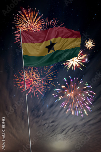 Waving National flag of Ghana and holiday fireworks in night sky