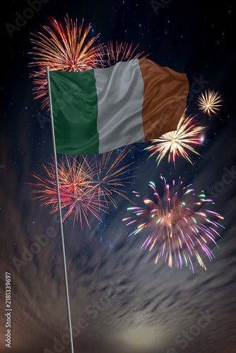 Waving National flag of Ireland and holiday fireworks in night sky