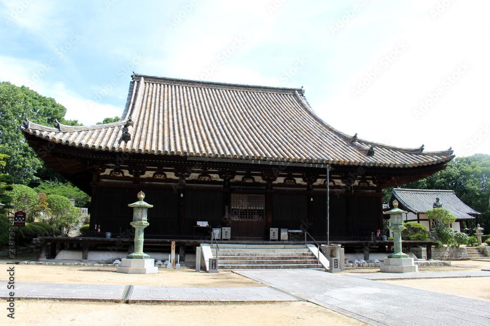Fototapeta premium Hondo Main Hall and Lantern Courtyard at Taisanji Temple (the 52nd) on Shikoku Henro Pilgrimage, Matsuyama, Japan, July 2026