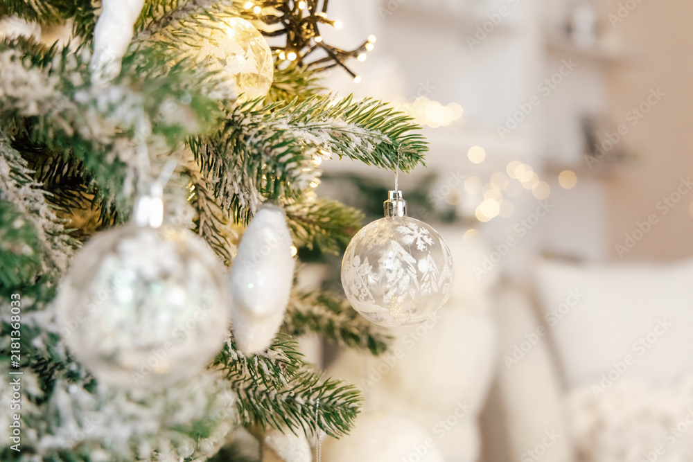 Obraz premium Christmas tree decoration with glass ornaments and warm lights in a cozy living room