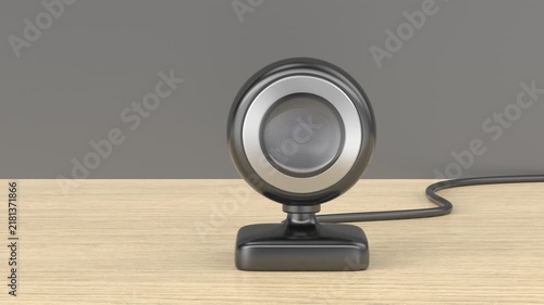 Black webcam or baby monitor on wooden table, front view