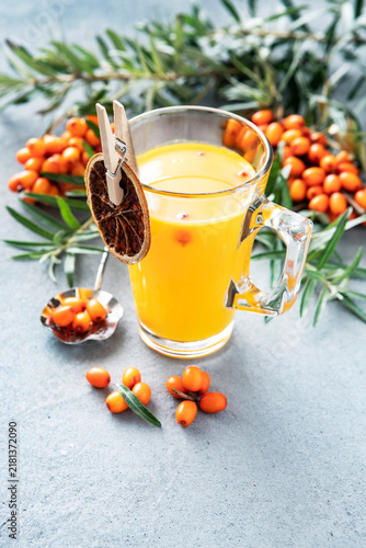 Glass cup with healing tea with sea-buckthorn