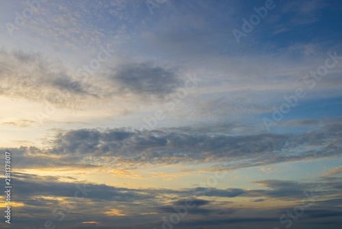 Fotografía Soft morning sky with gentle clouds and golden light,A wide view of a peaceful blue sky illuminated by soft golden sunlight, filled with gentle wispy clouds during early morning sunrise or evening