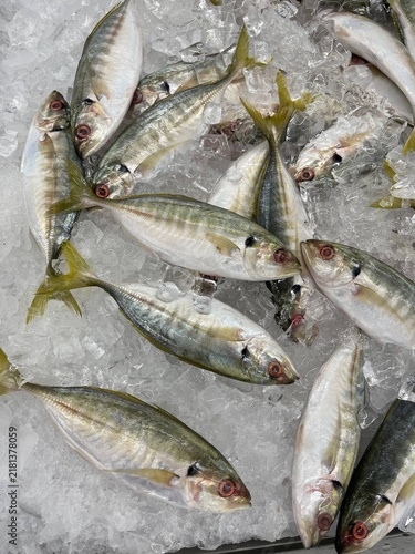 Картината върху платно Fresh fish displayed on crushed ice at seafood market for sale