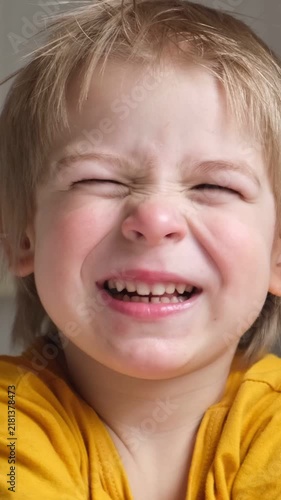 Boy joking, sticking tongue out with silly expression. Child making face. Funny foolishness portrait of little baby boy on white background. Adorable caucasian kid making crazy and comical gesture.