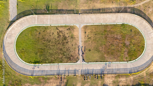 Aerial view of an oval cycling track with a grassy infield and people standing along the concrete perimeter in Bantul, Special Region of Yogyakarta, Indonesia.