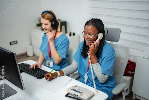 Medical call center nurses providing patient support at desk