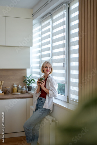 Woman enjoying morning coffee in cozy home kitchen