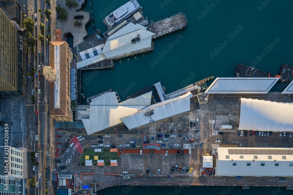 Obraz premium Top-down aerial view of Queens Wharf in Auckland, New Zealand, showcasing waterfront architecture, docks and ferry terminals at sunrise.