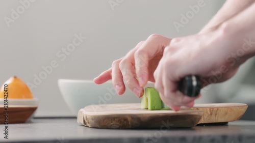 Man slicing ripe avocado on kitchen countertop side view