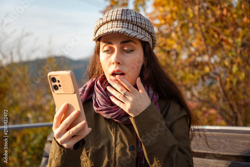 Obraz na płótnie Portrait of woman reacting with amazement while reading an unexpected message on smartphone