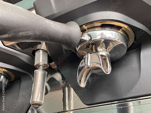 Close-up of a professional espresso machine portafilter and group head assembly