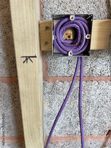 Electrical wiring installation with purple cable neatly coiled inside a metal junction box