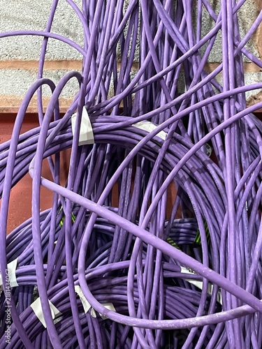 Tangled mass of purple network cables in a messy pile indoors