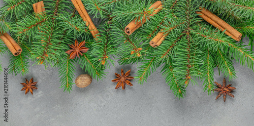 Konstfotografi Fresh evergreen branches with cinnamon sticks, star anise, and nutmeg arranged o