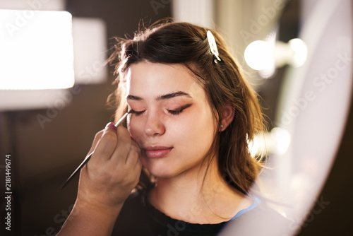 Foto Close-up shot of cosmetics brush blending brown eye shadow onto eyelid during beauty makeover session in professional studio
