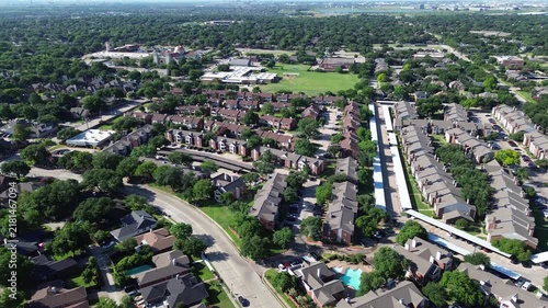 Residential subdivisions border Parkway Boulevard beside Saint Ann Catholic Parish grounds. Curved avenues, sparkling community swimming pools, shaded parking bays frame Coppell, Texas.