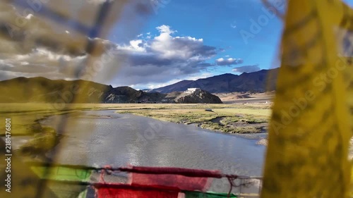 Hanle, India : Footage through prayer's flag river with hilltop Hanle gompa, a Tibetan Buddhist monastery in Hanle valley in Ladakh, India surrounded by  dramatic himalayan landscape on sunny day