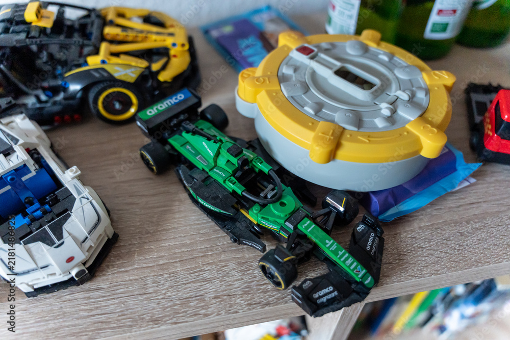 Obraz premium Warsaw, Poland - Sep 4, 2026: LEGO Technic vehicles and a yellow toy gyroscope arranged on a wooden shelf