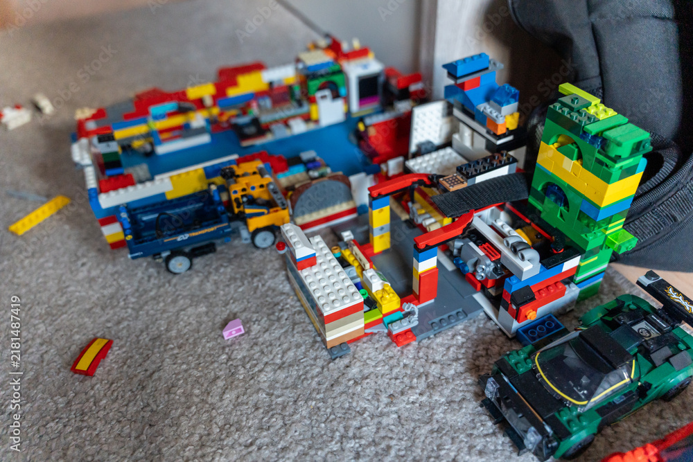 Obraz premium Warsaw, Poland - Sep 4, 2026: Piles of assorted LEGO building blocks and toy vehicles scattered on the floor