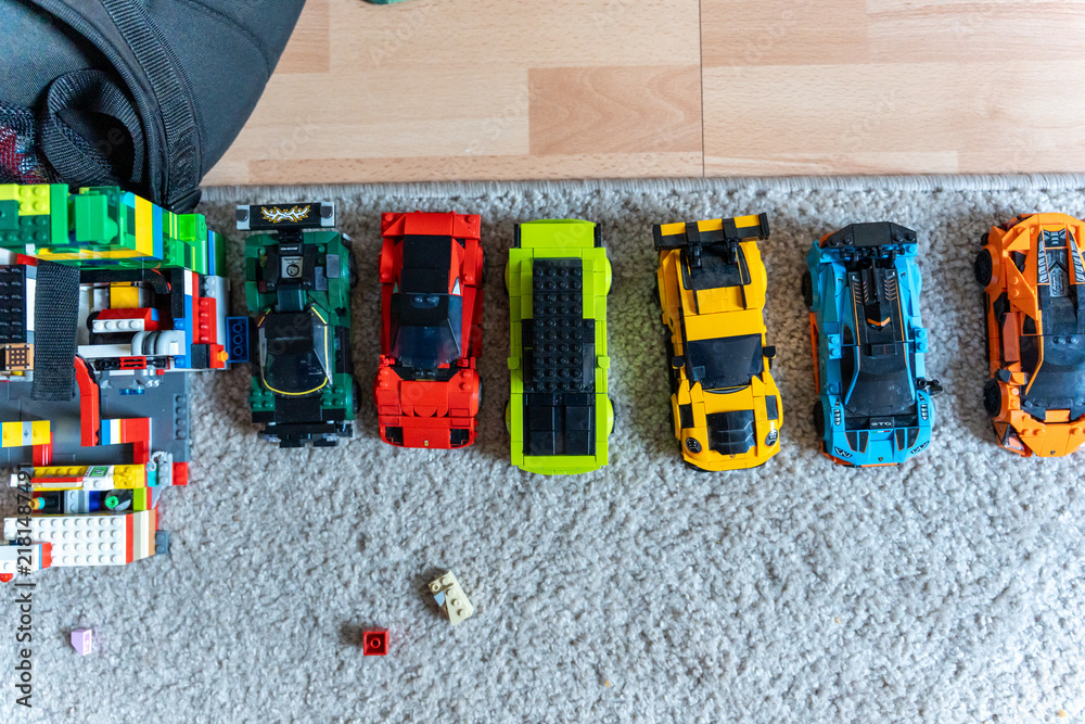 Obraz premium Warsaw, Poland - Sep 4, 2026: Row of seven LEGO Technic model cars in assorted colors on a gray carpet