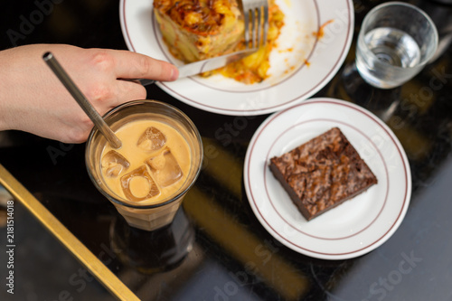 Foto A person reaches for a straw in an iced latte while dining at a brasserie in Paris, France