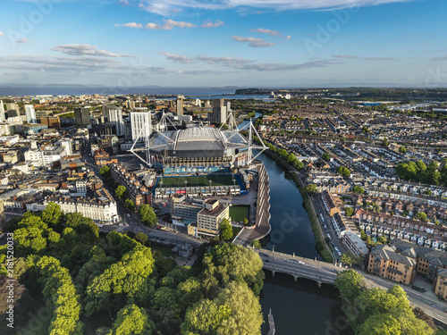 Cardiff, United Kingdom - 12 May 2026: Aerial view of Principality Stadium surrounded by urban architecture, the River Taff, and lush green trees under a clear blue sky.