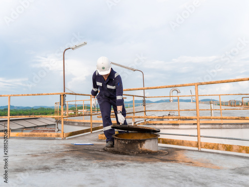 Petrochemical Engineers checking reports for technical inspections in oil refinery. Technicians working on checklist in the oil storage tank area. Factory and industry manufacturing. Oil tank.