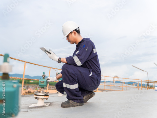 Petrochemical engineering checking controllers crude oil storage tank factory and industry. Maintenance engineer analysis work manufacturing production palm oil at refinery industrial plant. Fuel gas