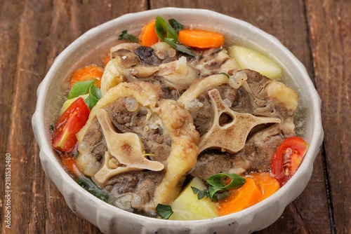 Фотография Sop buntut or oxtail soup, a traditional Indonesian oxtail soup made with tender beef oxtail simmered in a rich and flavorful broth with vegetables and aromatic spices