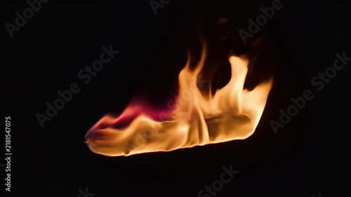 A surreal but photorealistic flame floating visually within an infinite black void, moving slowly as if surrounded by invisible currents. The flames ripple, curl, and stretch in elegant organic patter