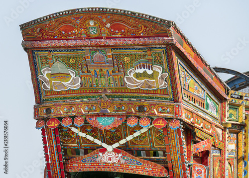 View of a vibrantly decorated truck featuring intricate patterns, religious motifs, and colorful paintwork in Dera Ghazi Khan, Punjab, Pakistan.