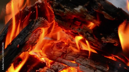 Seamless Looping Video of Hot Charcoal and Wood Fire. Ambient stock footage loop featuring glowing red charcoal, thermal energy, and roaring flames on stacked firewood.