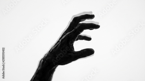 Silhouette of a Creepy Reaching Hand with Motion Blur and Double Exposure Effect on White Background