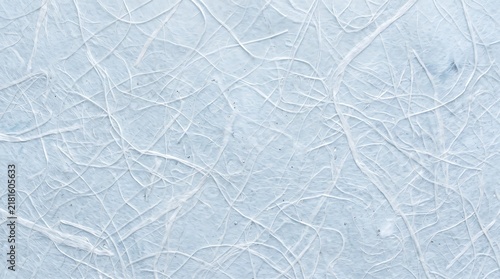 Textured handmade paper background featuring delicate light blue fibers intertwined in a soft artistic pattern for minimalist professional design projects