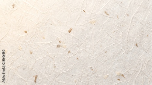 Handmade white mulberry paper texture with organic fiber patterns and light brown inclusions showcasing a rustic natural elegant aesthetic quality
