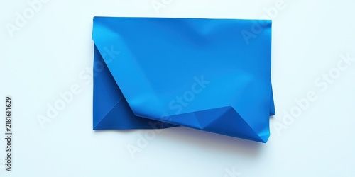 A smooth, folded blue fabric sheet against a white background. It creates an abstract, minimalist, and elegant design.