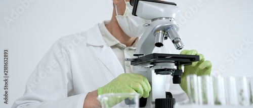 Foto Scientist wearing a face mask, safety goggles, and protective gloves, precisely