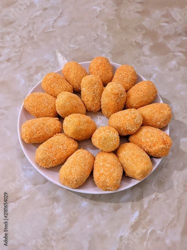 Quadro su tela Breaded croquettes arranged on a white plate, viewed from above