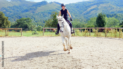 Foto Beautiful young girl on a white horse at an equestrian farm
